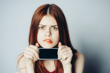 Elinde telefon olan güzel bir kadın teknoloji duyguları ile gülümsüyor.