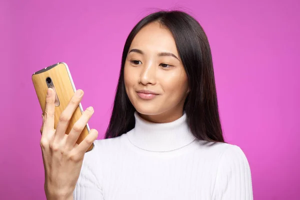 Милий азіатський зовнішній телефон в руці технологія інтернет-комунікації рожевий фон — стокове фото