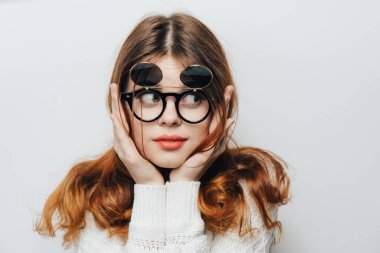 Beyaz süveter gözlüklü güzel bir kadın stüdyo çekici saçları var.