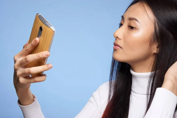 Жінка азіатської зовнішності дивиться на телефонні технології інтернет-зв'язок — стокове фото