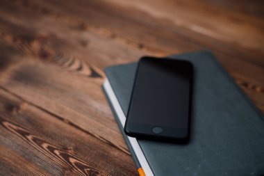 ahşap kapaklı cep telefonu ve kitap