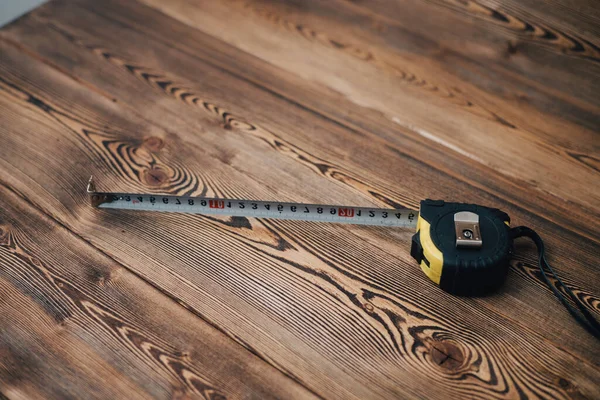 Centimeter tape op houten tafel achtergrond afbeelding hamer bovenaanzicht — Stockfoto