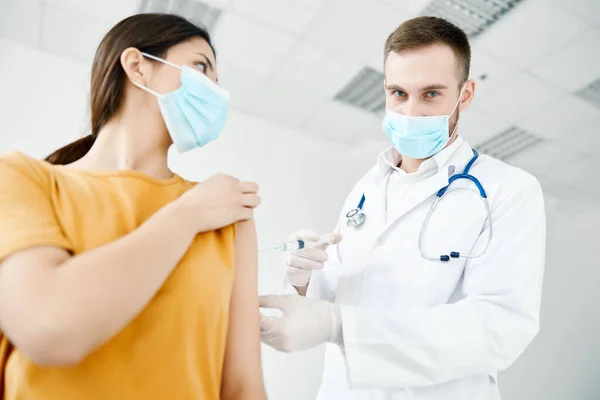손에 주사기를 쥐고 있는 의사의 의료용 마스크 환자가 백신 접종을 공모하는 모습 — 스톡 사진