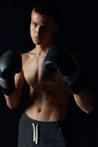 Sport ragazzo su un nero sfondo in boxe guanti gonfiato busto ritagliato vista modello — Foto Stock
