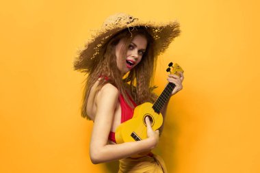 Kırmızı ukulele tişörtlü neşeli kadın egzotik meyve sarısı arka plan yaşam tarzı
