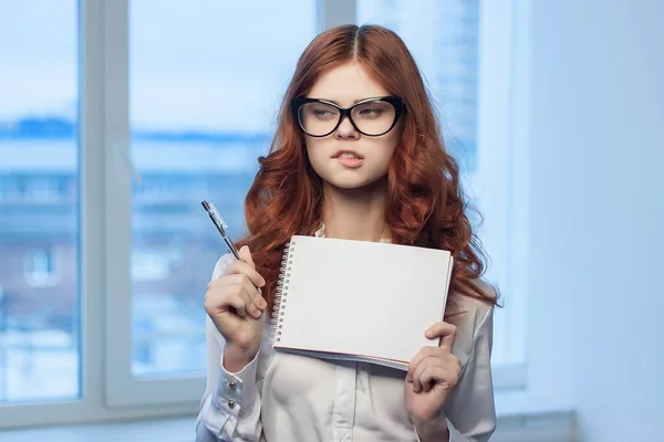 Mulher ruiva em óculos com um caderno nas mãos um gerente oficial — Fotografia de Stock