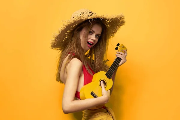 Wesoła kobieta w czerwonym ukulele t-shirt Egzotyczne owoce żółty tło styl życia — Zdjęcie stockowe