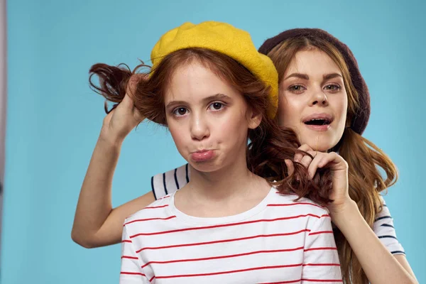 Hermanas de moda en sombreros divertido estilo de vida estudio de fondo azul —  Fotos de Stock