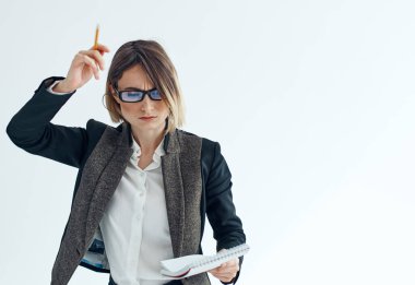 İş kadını, elinde belgelerle hafif bir arkaplanda el kol gezer.