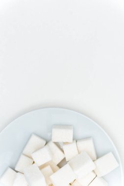 Bir tabak tatlı üzerinde granüle şeker küpleri hafif arka plan