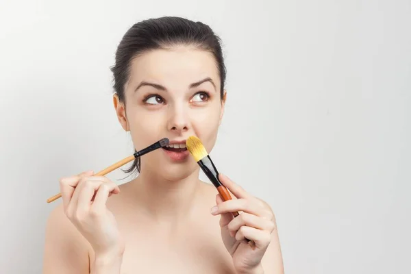 Wanita mengaplikasikan krim kuas pada peremajaan perawatan kulit wajah — Stok Foto