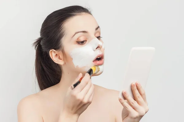 Atractiva mujer con hombros desnudos aplicando maquillaje cuidado de la piel —  Fotos de Stock