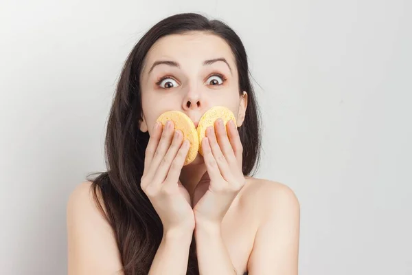 Woman with bare shoulders wipes her face with sponges — Stock Photo, Image