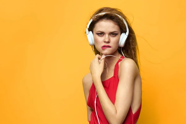 Mujer bonita en rojo camiseta auriculares música fondo amarillo —  Fotos de Stock