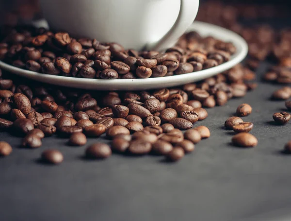 Bílý šálek s kávovými zrny na šedém pozadí odrůdy Arabica — Stock fotografie