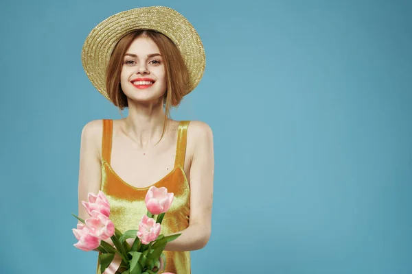 Glada kvinna i en hatt bukett blommor semester gåva charm blå bakgrund — Stockfoto