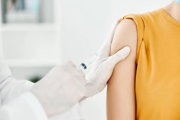 Hivatásos orvos fogja a kezét a vállán egy nő vakcinázás — Stock Fotó
