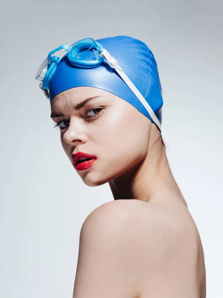 Вид сбоку на красивую женщину в голубой плавательной шапке, голые плечи — стоковое фото
