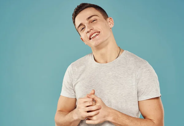 Fröhlich schöner Mann in einem weißen T-Shirt Studio blauer Hintergrund — Stockfoto