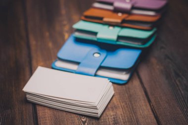 Tahta bir arka planda çok renkli kartvizit tutucuları ve bir paket beyaz kağıt Boşluğu Kopyala