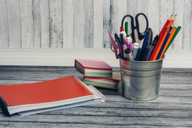 kırmızı not defteri ve kırtasiye duruşu makas renkli kalemler okul işaretleri