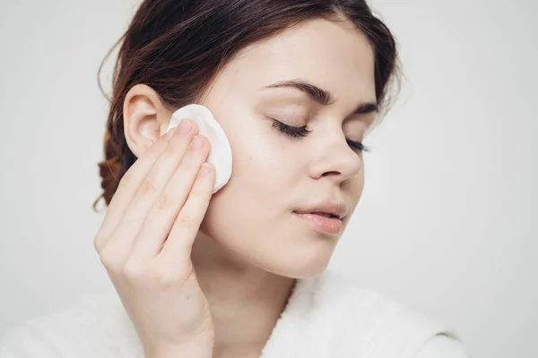 Vrouw veegt haar gezicht met een witte zachte spons schoonheid zorg model — Stockfoto