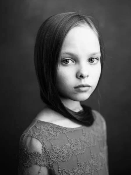 Portrét malé holčičky v šatech na tmavě šedém pozadí fotografie oříznutý boční pohled — Stock fotografie