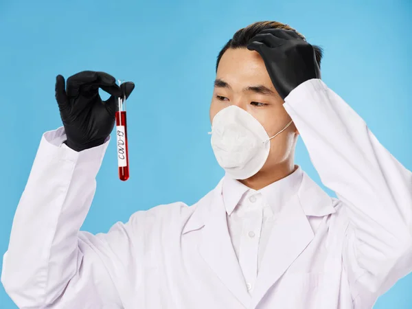 Man laboratorieassistent skyddsdräkt blodprov undersökning svarta handskar — Stockfoto