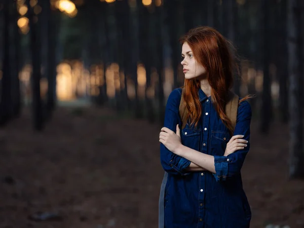 Mujer bonita viaja en el bosque con una mochila en la espalda y en una camisa azul —  Fotos de Stock