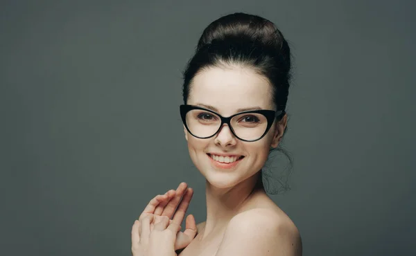 Pretty brunette with glasses naked shoulders attractive look dark background — Stock Photo, Image