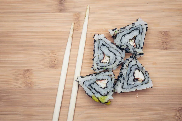 Rollos de sushi palillos comida ración delicadeza madera tablero cocina japonesa — Foto de Stock