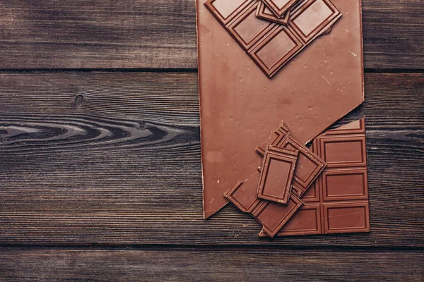 Шоколадная плитка на деревянном фоне и конфеты текстуры — стоковое фото
