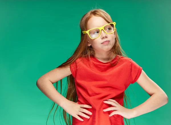 Aranyos vörös hajú lány érzelmek sárga szemüveg képzés zöld háttér — Stock Fotó