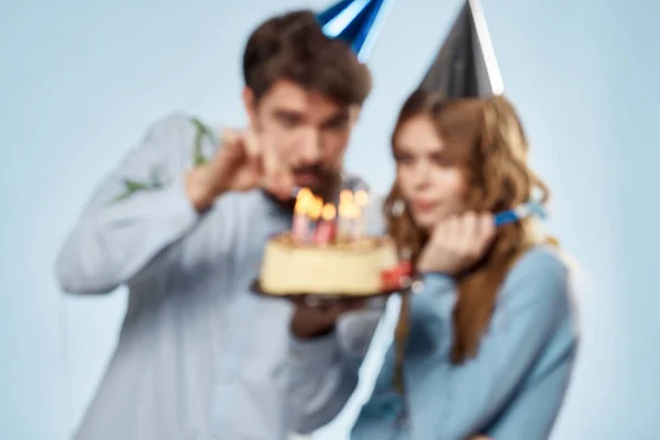 En man och en kvinna håller en födelsedagsfest fest tårta med ljus i handen — Stockfoto