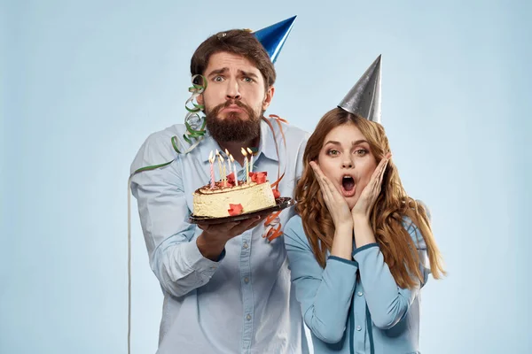 Emotionaler Mann mit Kuchen und hübscher Frau Party Disco blauer Hintergrund — Stockfoto