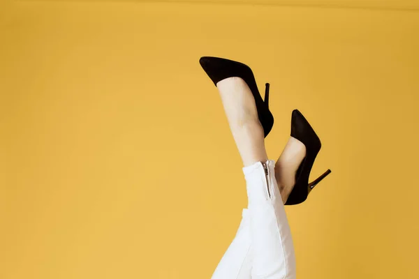 Donne invertito nero scarpe moda giallo sfondo — Foto Stock