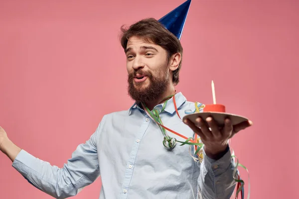 Bearded man with cake on pink background birthday party corporate emotions model loneliness