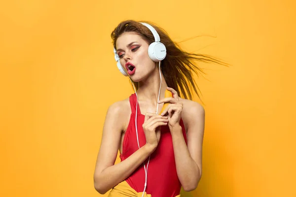 Emotional woman in white headphones listens to music fun lifestyle yellow background — Stock Photo, Image