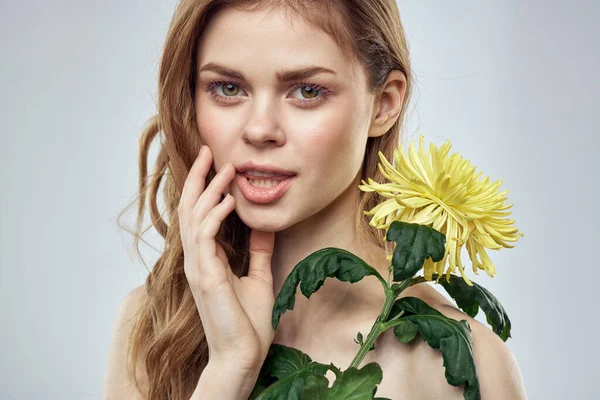 Portrét krásné ženy se žlutou květinou na světlém pozadí okouzlující úsměv model zrzavé vlasy — Stock fotografie