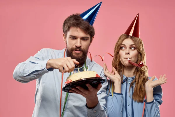 Party man och kvinna med tårta på rosa bakgrund företags födelsedag — Stockfoto