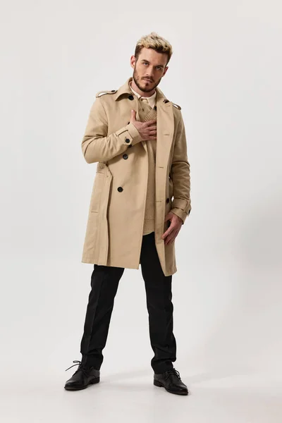 Стильний молодий чоловік в легкому пальто і штани повної довжини в приміщенні — стокове фото
