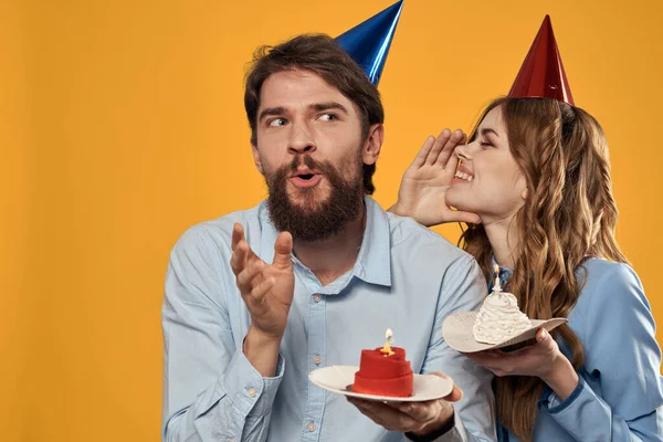 Geburtstagsparty Mann und Frau Spaß gelb Hintergrund Mütze Urlaub — Stockfoto