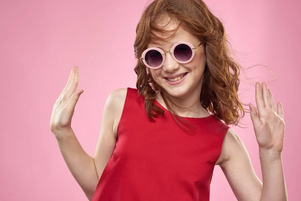 Chica con pelo rizado gafas redondas oscuras divertido vestido rojo fondo rosa — Foto de Stock