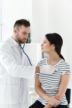 Erkek doktor hastanedeki hastayı dinler. 