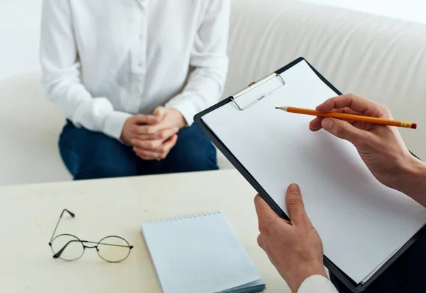 Männlicher Psychologe mit Dokumenten und Frau drinnen — Stockfoto