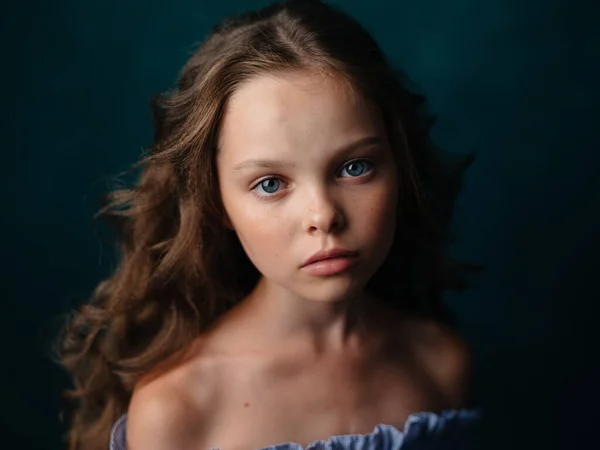 Adorable chica con el pelo rizado desnudo hombros azul vestido de fondo oscuro — Foto de Stock