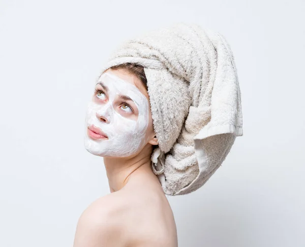 Happy woman with towel on head naked shoulders moisturizer on face mask — Stock Photo, Image