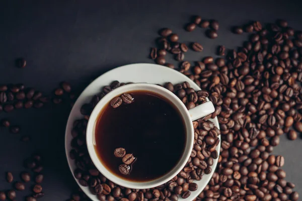 Filiżankę z aromatycznym napojem i ziarnem kawy wokół spodek widok z góry — Zdjęcie stockowe