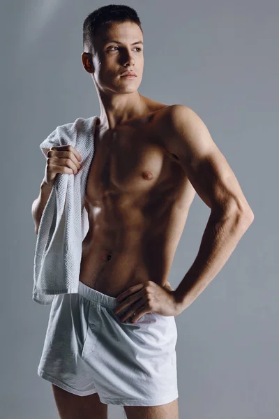 Homem atleta de mãos dadas no cinto e toalha no ombro cinza fundo recortado vista — Fotografia de Stock
