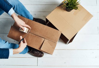 Kutu paketleyen adam ofis görevlisini taşıyor.